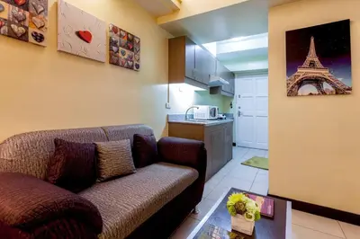 a living room with a couch and a kitchen at Tivoli Garden Residences - Iris Tower in Manila