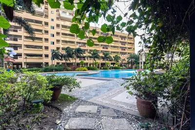 a swimming pool in front of a large building at Tivoli Garden Residences - Iris Tower in Manila