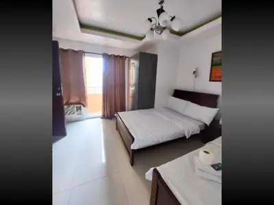 a bedroom with two beds and a table in it at Family Room Staycation In The Heart Of Manila, with 2 Balcony Plus 40 Percent Promo Discount Plus Free Pool Access, Plus Free Sauna Promo in Manila Bay, Robinsons Place, Ermita, Pgh, Bellagio, UP Pedrogil, Staycation Updated 2025 Price in Manila
