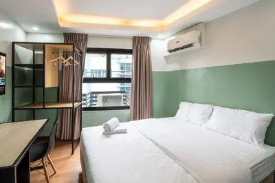 a bedroom with a bed and a desk and a window at St. Marvin Studio Makati M303 in Manila