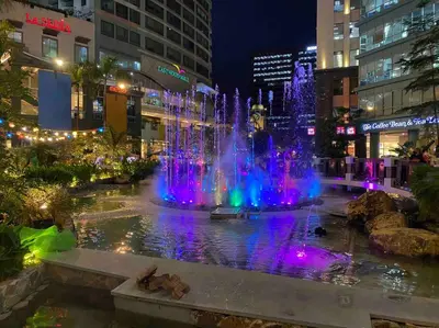 a fountain in the middle of a city at night at Awesome Eastwood Condo Suite! in Manila