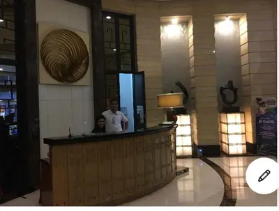 a man and a woman standing at a counter in a lobby at Awesome Eastwood Condo Suite! in Manila