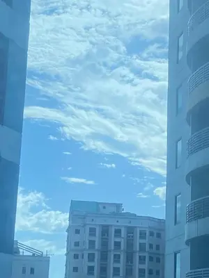 a view of two tall buildings and a cloudy sky at Elegant 2BR, 2 BA Suite Beside Eastwood Mall in Manila