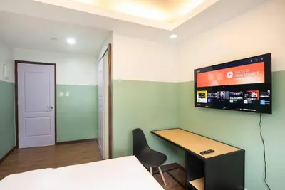 a room with a desk and a tv on the wall at St. Marvin Studio Makati M204 in Manila