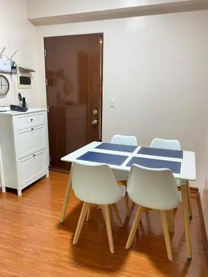a table and chairs in a room with a kitchen at Anuva Residence Condominium in Manila