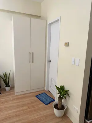 a room with a white closet and a blue rug at Neat Unit in Holland Park Southwoods in Biñan