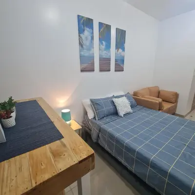 a living room with a bed and a table at Homely Green 2 Residences T2 in Dasmariñas