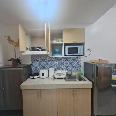 a small kitchen with a sink and a refrigerator at Homely Green 2 Residences T2 in Dasmariñas