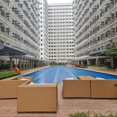a large building with a swimming pool in front of it at Homely Green 2 Residences T2 in Dasmariñas
