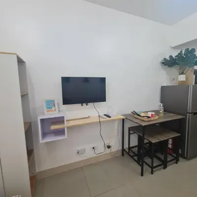 a room with a desk with a television on a wall at HOMELY @ Green 2 Residences SMDC DLSUMC in Dasmariñas