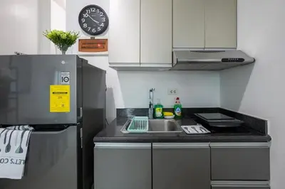 a kitchen with a sink and a refrigerator at The Beacon Makati by mvmtransient in Manila