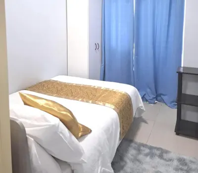 a bedroom with two beds with blue curtains at FourSphere staycation in Manila