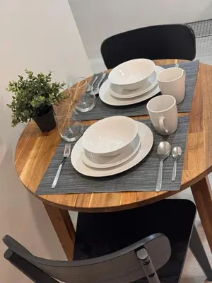 a wooden table with plates and silverware on it at Morgan Suites Executive Residences in Manila