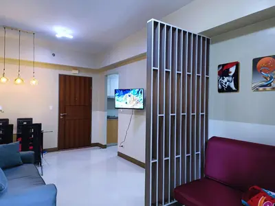 a living room with a partition with a couch and a tv at 1BR at TWO PALMTREE VILLAS Across Manila airport terminal 3 in Manila