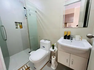 a bathroom with a toilet and a sink and a shower at Richjones Bed & Breakfast in Manila
