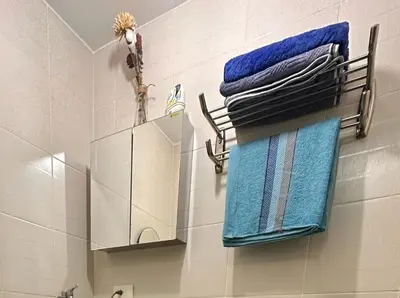 a bathroom with two towels and a mirror on a wall at Condo with Balcony at Makati SM Jazz in Manila