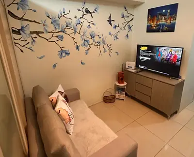 a living room with a couch and birds on the wall at Condo with Balcony at Makati SM Jazz in Manila