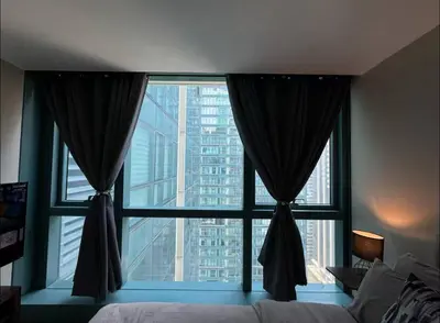 a bedroom with a large window with a view of a city at Modish 1BR One Uptown BGC direct to Uptown Mall in Manila
