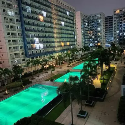 an overhead view of a pool with palm trees and buildings at Sea Residence Finest in Manila