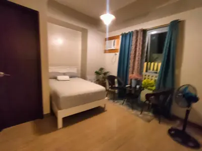 a bedroom with a bed and a table and chairs at The Verdin at Maple Grove in Cavite
