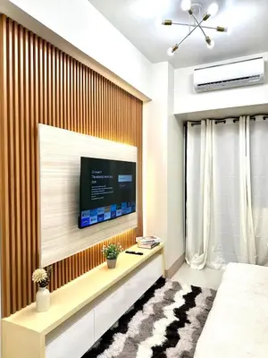 a living room with a television on a wall at SMDC Shore 3 Residences - One Bedroom Unit in Manila