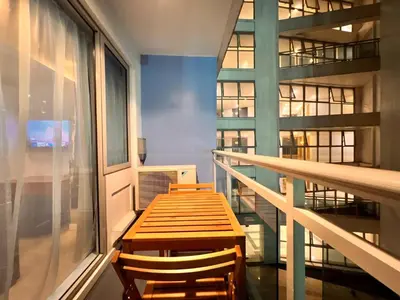 a wooden table and two chairs in a balcony at Manila Philippines, Azure Urban Resort Staycation by Leroche near Ninoy Aquino International Airport in Manila