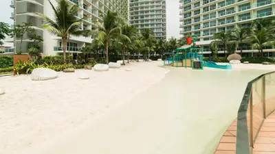 an empty beach in a resort with palm trees and buildings at Manila Philippines, Azure Urban Resort Staycation by Leroche near Ninoy Aquino International Airport in Manila