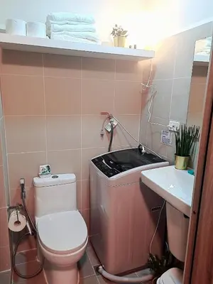 a small bathroom with a toilet and a sink at Cozy Penthouse 2BR Suite w Balcony - Amazing Manila Bay View and City Skyline near MOA in Manila