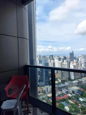a balcony with a red chair and a view of a city at Homestead in Manila