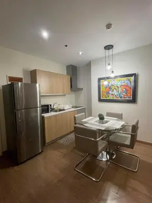 a kitchen with a table and a stainless steel refrigerator at Homestead in Manila