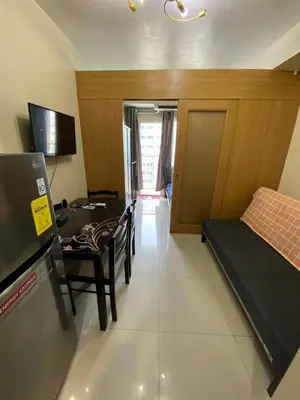 a living room with a table and a bed and a room at Shell Residence Moa - Anne in Manila