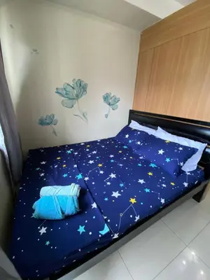 a bed with a blue comforter with stars on it at Shell Residence Moa - Anne in Manila