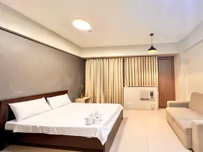 a hotel room with a bed and a couch at Elegant Condo Hotel across NAIA Airport Terminal 3 Newport City in Manila