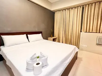a bedroom with a bed with a roll of toilet paper on it at Elegant Condo Hotel across NAIA Airport Terminal 3 Newport City in Manila