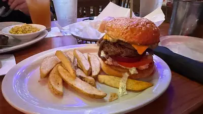 a plate with a hamburger and french fries on a table at Cozy Condo near Mall of Asia in Manila