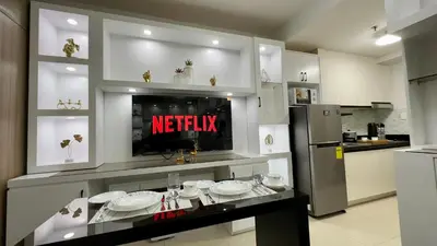 a kitchen with a counter with white dishes on it at Cozy Condo near Mall of Asia in Manila