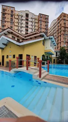 a large swimming pool in front of a building at Cozy Studio Unit near Manila Airport With Swimming Pool, Full Kitchen 7A in Manila