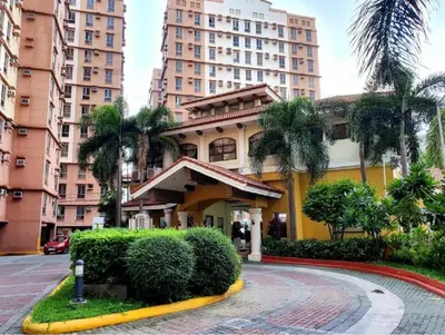 a building in a city with tall buildings at Cozy Studio Unit near Manila Airport With Swimming Pool, Full Kitchen 7A in Manila