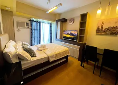 a bedroom with a bed and a tv on the wall at Modern Bayview Condo in 8 Adriatico in Manila
