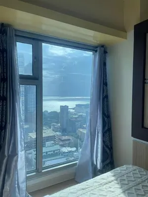 a bedroom with a large window with a view at 8 Adriatico Staycation in Manila