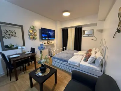 a bedroom with a bed and a desk and a room with a desk at 8 Adriatico Staycation in Manila