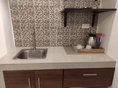 a kitchen with a sink and a counter top at Nest Fort BGC in Manila