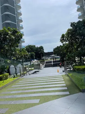 a walkway in a park next to a tall building at Azure Urban Resort Residences in Manila