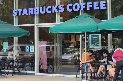 people sitting at tables in front of a starbucks coffee shop at Chill Apartment in Makati in Manila
