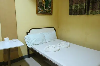 a small room with a bed with two towels on it at Villa Elsie Resort and Hotel in General Trias