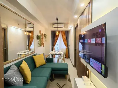 a living room with a green couch and a flat screen tv at Happirest at S Residences w/Balcony, Mall of Asia in Manila