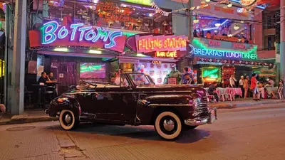 an old black truck parked on a city street at night at Near Manila Airport, MAILZ HOMEZ COZY 1 Bedroom Condo, Full Kitchen, Swimming Pool, WIFI, 10L in Manila