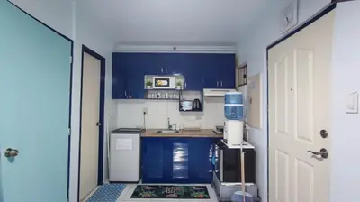 a small kitchen with blue cabinets and a sink at Near Manila Airport, MAILZ HOMEZ COZY 1 Bedroom Condo, Full Kitchen, Swimming Pool, WIFI, 10L in Manila