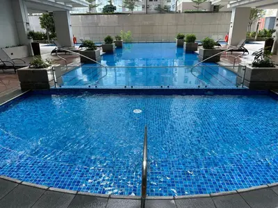 a large pool with blue water in a building at Modern Suite In Bonifacio Global City in Manila