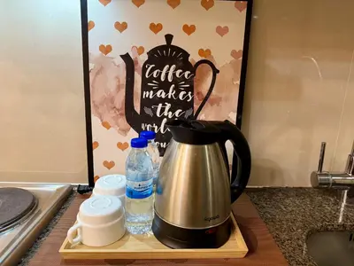 a coffee maker and water bottles on a kitchen counter at Modern Suite In Bonifacio Global City in Manila